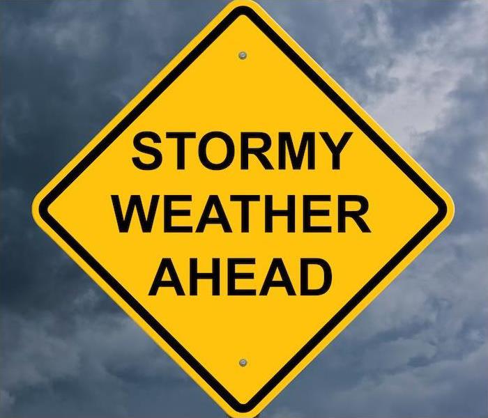 a large yellow warning sign stating that there is stormy weather ahead