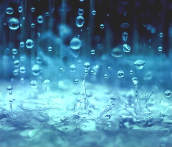 bright blue rain splashing into a pool of water